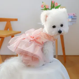 Close-up of pink pet dream gauze dress with satin bow on a white Bichon Frise dog