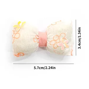 Detailed size view of floral bow hair clip for dogs and cats, measuring 5.7cm by 3.4cm