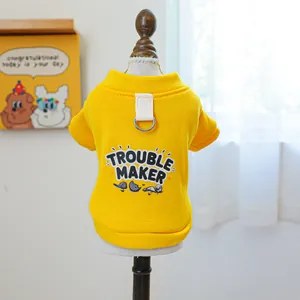 Detail eines gelben Hunde-Hoodies mit Trouble Maker Aufdruck und Metall-D-Ring für Leinen
