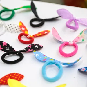 Close-up of colorful bunny ear elastic hair bands for pets in various floral patterns