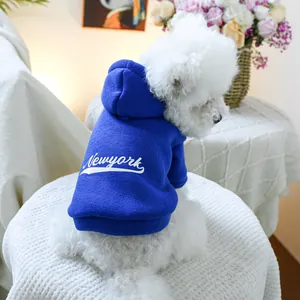 Detail of navy blue pet hoodie with white New York lettering on a small white dog