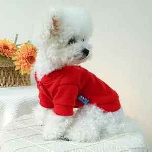 Detail of red pet cotton hoodie with ribbed cuffs on a white Bichon dog model