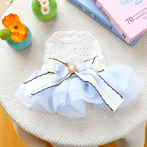 Dettaglio vestito per cani in pizzo bianco, tutu in organza blu e fiocco di perle