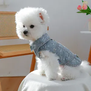 Dettaglio del gilet in denim azzurro per cani con ricamo floreale bianco e anello a D in metallo