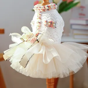 Close-up of white lace pet dress featuring 3D roses and layered tulle skirt details