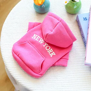 Close-up of pink dog hoodie with white New York text and soft cotton knit texture
