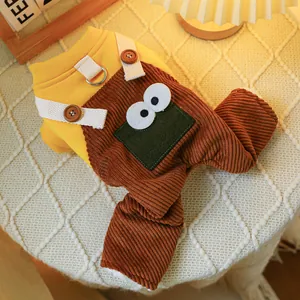 Detail of pet jumpsuit featuring warm yellow fabric, corduroy texture, and green cartoon eyes