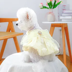 Yellow pet dress for small dogs featuring a large bow with pearl trim and gemstone
