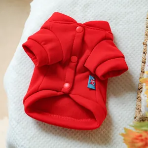Detail of red pet sweatshirt featuring round snap buttons and soft fleece texture