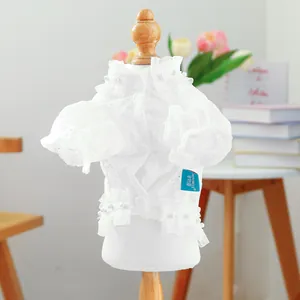 Detail of white lace pet shirt featuring puff sleeves and elegant faux pearl embellishments