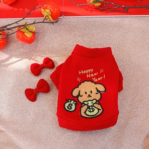 Close-up of red festive pet sweatshirt with gold embroidery and bow hairpins