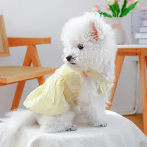 Dettaglio di vestito giallo per cani con ricamo di margherite e bordo di perle fini