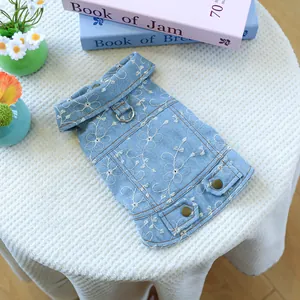 Dettaglio del gilet in denim per cani azzurro con ricami floreali bianchi e anello a D