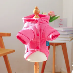 Pink dog hoodie detail with brand woven label and three matching buttons on wooden mannequin