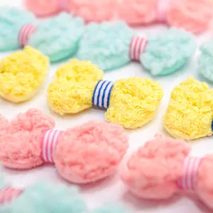 Detailed view of colorful plush bow clips for pets in soft pastel macaroon shades