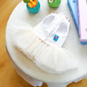 Detail view of white pet dress with lace bodice, colorful beads and layered tulle skirt