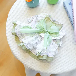 Close-up of pet dress with green satin, heart lace layers and large bow detail