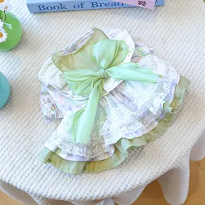 Detail of floral pet dress featuring a green organza bow and layered white lace trim