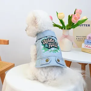 Dettaglio gilet in denim azzurro per cani con ricamo Wild & Free e anello a D in metallo