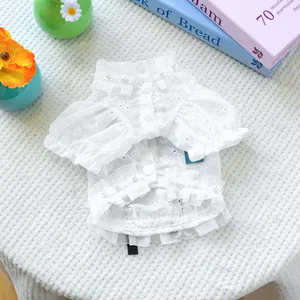 Close-up of white pet lace shirt with daisy embroidery and elegant pearl button details