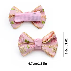 Detailed size view of pink floral embroidered pet bow clips with gold edge and metal clip