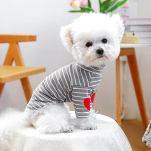 Close-up of gray striped dog sweater with a red heart patch and warm ribbed knit texture