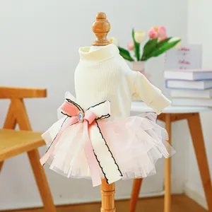 Detail of pet dress with white knit top, pink mesh skirt and large ribbon jewel bow
