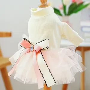 Detail of pet dress featuring cream knit top and pink tiered mesh skirt with jewel bow