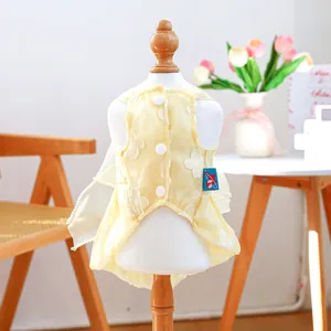 Dettaglio di un vestito giallo chiaro per cani con ricami floreali e bottoni a pressione