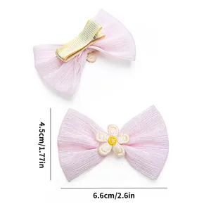 Detailed view of pink bow hair clip with flower decor and exact dimensions in inches