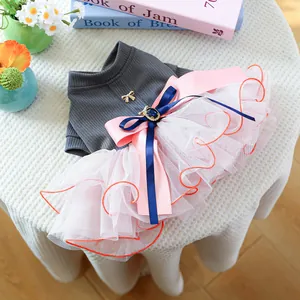 Detail of grey knitted dog dress with pink tulle skirt and blue gem bow ornament