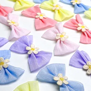 Detail of colorful macaron fabric bow clips with white floral embroidery for pets