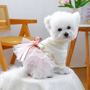 Detail of pink mesh tutu skirt and bow on white striped pet dress for small dogs