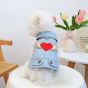Dettaglio del gilet di jeans per cani con ricamo a cuore rosso e ali di paillettes