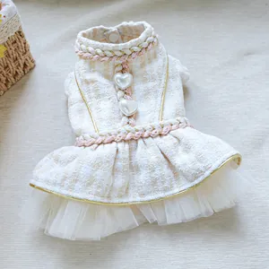 Detailed close-up of tweed pet dress with heart pearl buttons and white lace hem