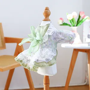 Detail of floral pet dress with large green bow and tiered white lace trimmings