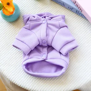 Detail of purple pet hoodie with resin snap buttons and ribbed cuffs on soft blanket