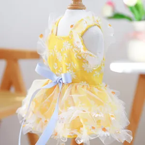 Detail of yellow pet summer dress featuring white daisy embroidery and gauze ruffles