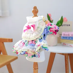 Detailed close-up of floral pet dress with lace edges and pink silk bow decoration