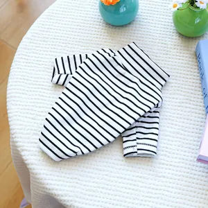 Flat lay of a black and white striped ribbed dog shirt on a white waffle texture surface