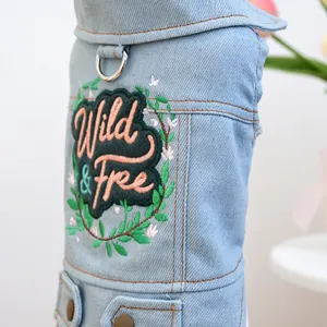 Dettaglio del ricamo Wild & Free su gilet in denim per cani con anello a D in metallo