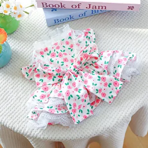 Detailed close-up of pink floral pet dress with white lace trim and big bow on top