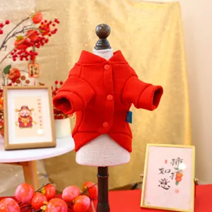 Macro shot of red fleece pet vest with buttons and festive New Year decorations