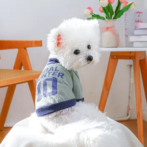 Close-up of green dog shirt with blue Goal Hunter 10 print in cozy home setting