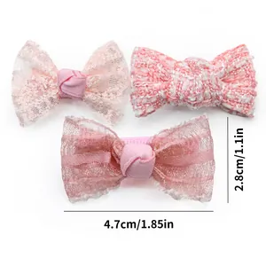 Detailed view of pink bow hair clips with lace, tweed, and tulle textures for pets