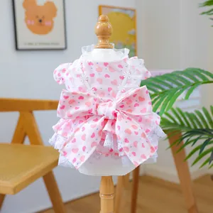 Close-up of pink pet dress with heart pattern, lace trim and a large decorative bow