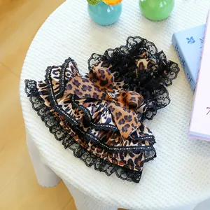 Detail of leopard print pet tutu dress with multi-layered black lace and jeweled bow