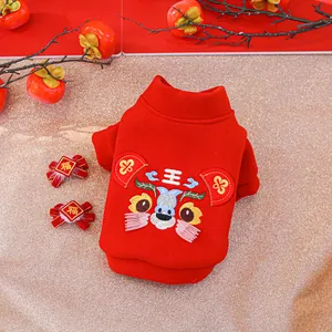 Detail of red pet New Year hoodie with traditional lion embroidery and Fu bow accessories