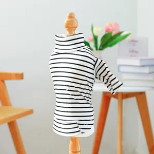 Detail of pet striped turtleneck sweater on a wooden mannequin in a cozy home setting