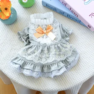 Detailaufnahme des grauen Hundezahn-Haustierkleides mit Spitze und gelber Schleife